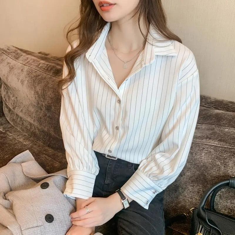 A model wearing a striped classic long sleeve shirt in a chic office look